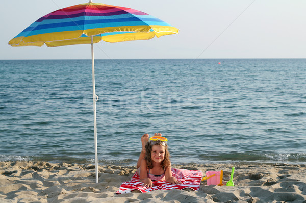 little girl with diving mask lying under sunshade on beach Stock photo © goce