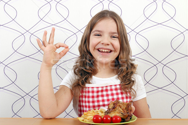 happy little girl with roasted chicken wings and ok hand sign Stock photo © goce