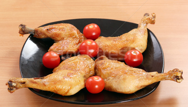 chicken drumstick and tomatoes on black dish Stock photo © goce