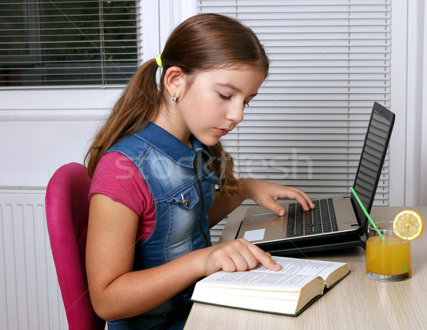 little girl studies with a book and a laptop at home Stock photo © goce