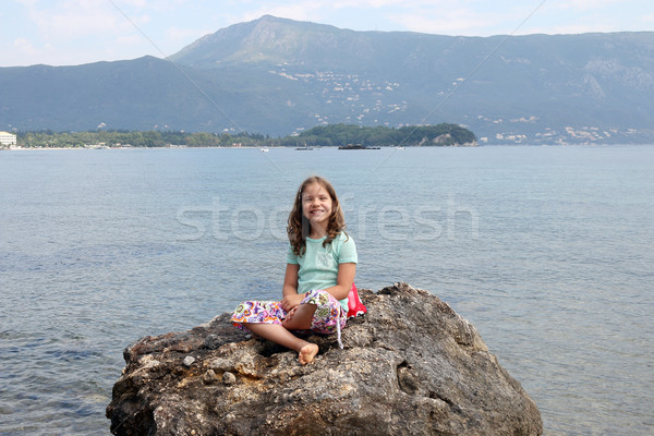 happy little girl sitting on a rock by the sea  Stock photo © goce
