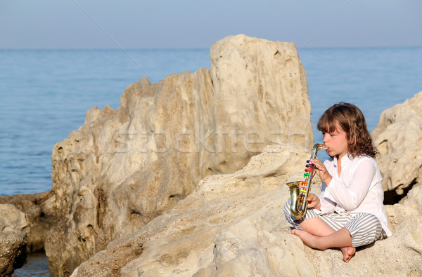 little girl playing saxophone by the sea Stock photo © goce