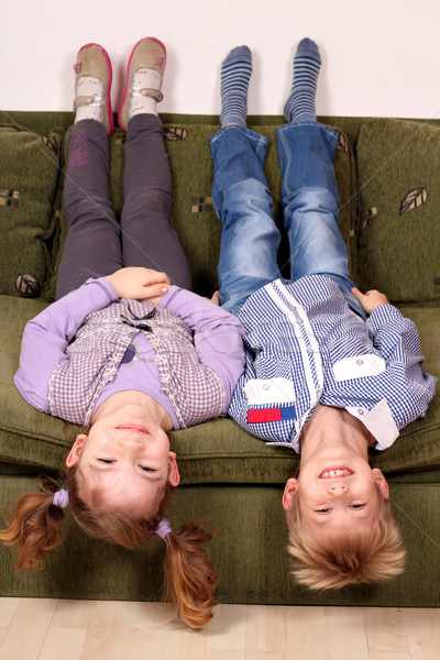 little girl and boy lying upside down on the bed Stock photo © goce