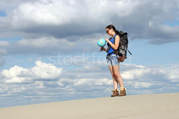 girl hiker looking at a globe where they will travel Stock photo © goce