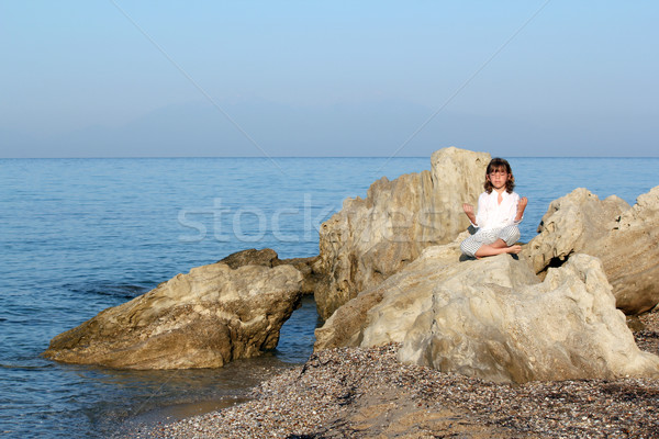 little girl sitting on a rock by the sea and meditate Stock photo © goce