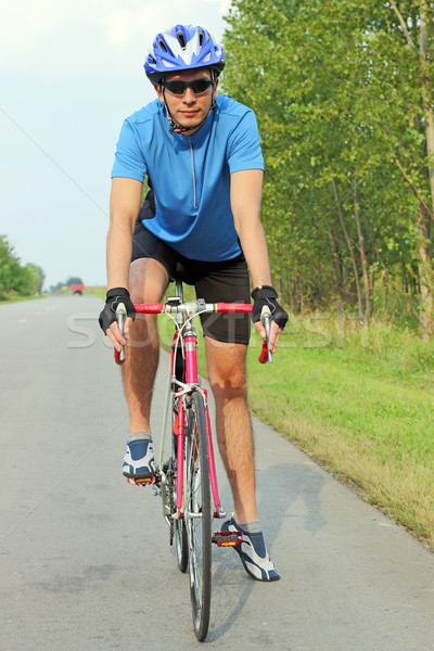 male cyclist riding a bike on an open road Stock photo © goce