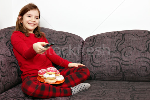 little girl watching tv and eating donuts Stock photo © goce