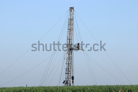 oil drilling rig behind green wheat field Stock photo © goce