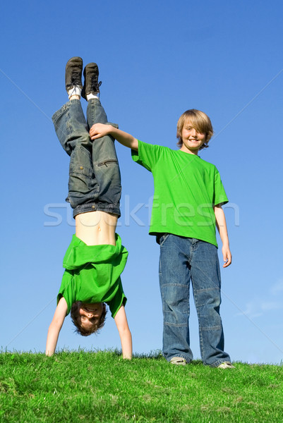 twins, twin brothers playing outside, in summer one upside, down. Stock photo © godfer