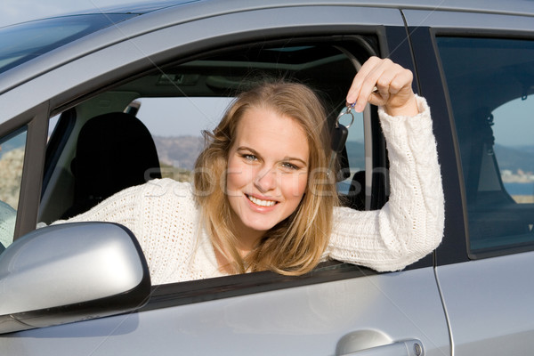 young woman holding key to new, hire or rental car after passing, driving test Stock photo © godfer