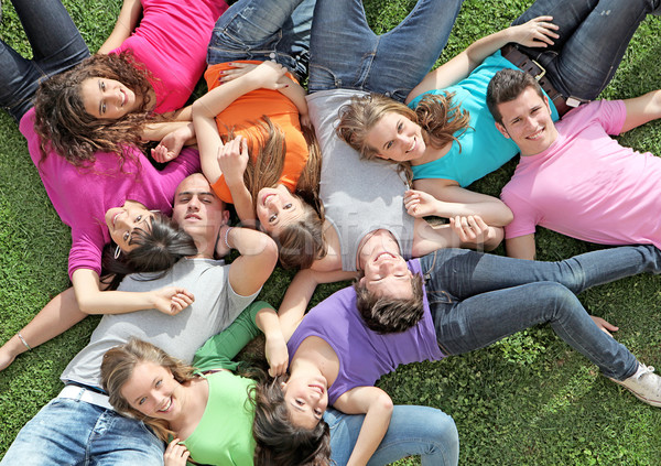 group of happy healthy kids laying outdoors on grass at summer camp Stock photo © godfer