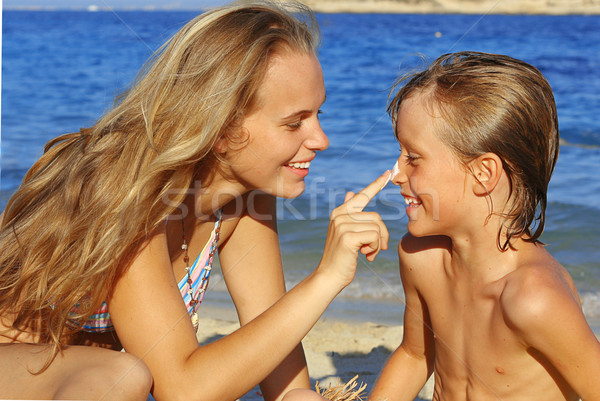 mother putting sun cream on child in summer Stock photo © godfer