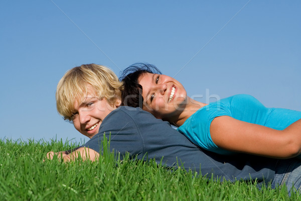 happy smiling, teen couple laying on grass in summer Stock photo © godfer