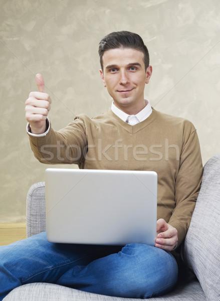 Man on couch with laptop showing ok sign Stock photo © goir