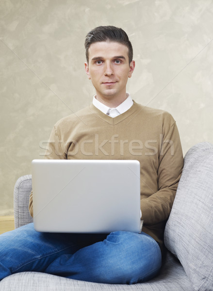 Homem laptop olhando câmera sofá trabalhando Foto stock © goir