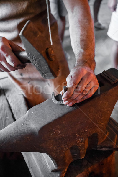 The blacksmith forging glowing horseshoe Stock photo © grafvision