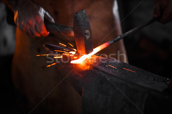 Blacksmith manually forging the molten metal  Stock photo © grafvision