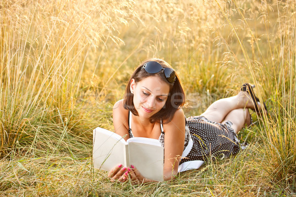 Woman lies on grass and reads book Stock photo © grafvision