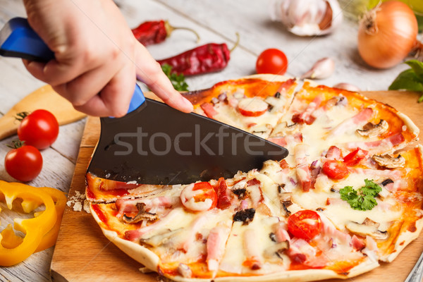 Cutter cuts a fresh pizza Stock photo © grafvision