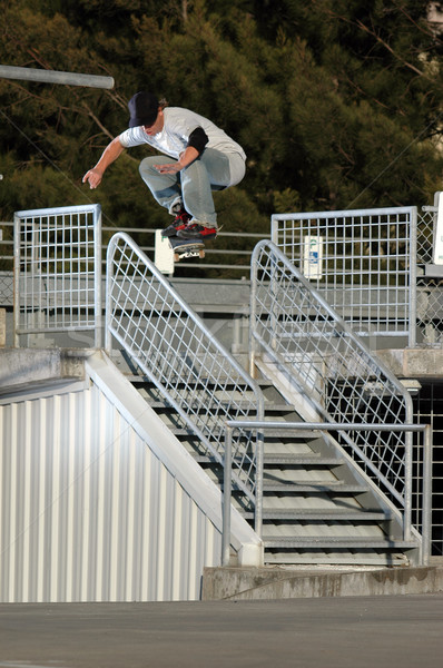 Giovani skateboarder jumping corrimano parcheggio Vai Foto d'archivio © gravityimaging