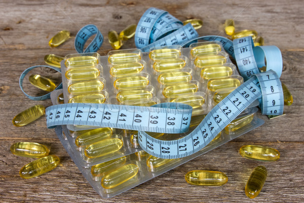 Olio di pesce capsule nastro di misura legno medici salute Foto d'archivio © Grazvydas