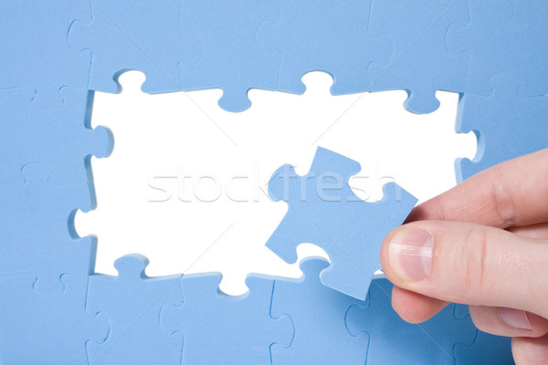 Hand collecting  blue puzzle  Stock photo © Grazvydas