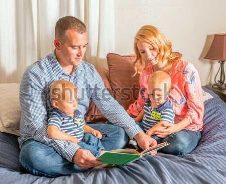 Young Hispanic Man With Caucasian Woman Reading to Twin Baby Boy Stock photo © gregorydean