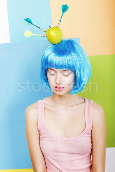 Joke. Eccentric Woman Oddball in Blue Wig with Darts and Green Apple Stock photo © gromovataya