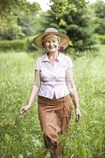 Serenity. Friendly Senior Peasant Woman in Straw in Meadow Smiling Stock photo © gromovataya