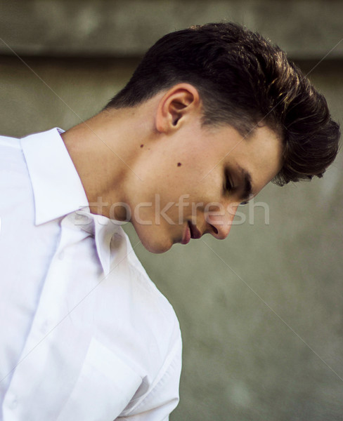 Prawdziwy wyrafinowany młody człowiek biały shirt patrząc w dół Zdjęcia stock © gromovataya