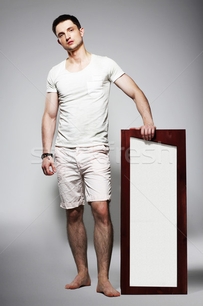 Full Length of Young Barefoot Man in White Shorts with Plackard Stock photo © gromovataya