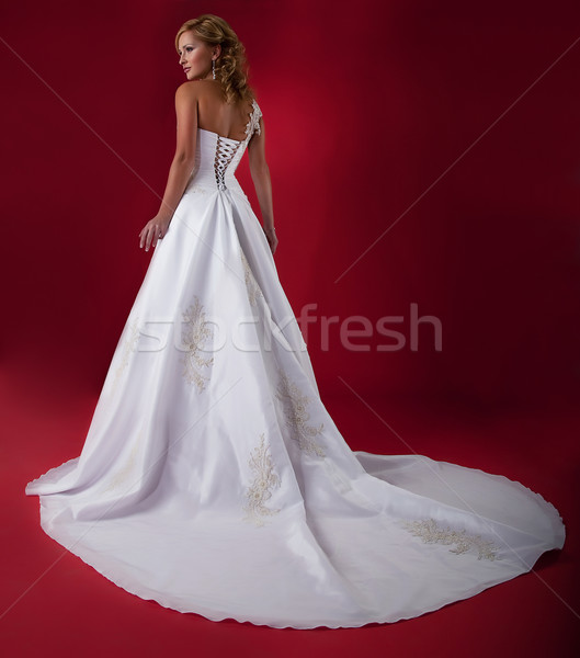 Bride fashion model in long white bridal dress on red background Stock photo © gromovataya