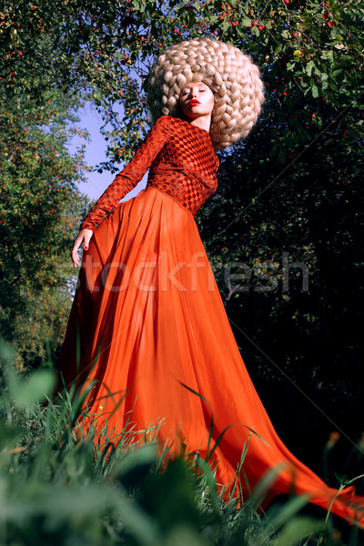 Fantasy. Artistic Stylized Woman in Trendy Red Dress and Big Frizzy Wig Stock photo © gromovataya