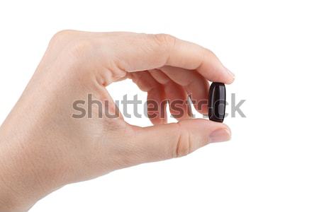 Stock photo: Woman's hand holding black pill