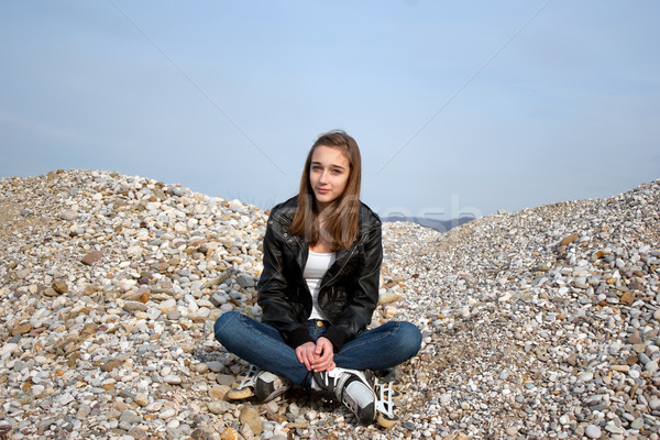 Teenage girl with rollerblades sitting on pebbles Stock photo © gsermek