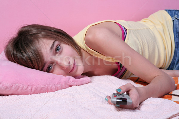 Teenage girl laying on the bed with remote control Stock photo © gsermek