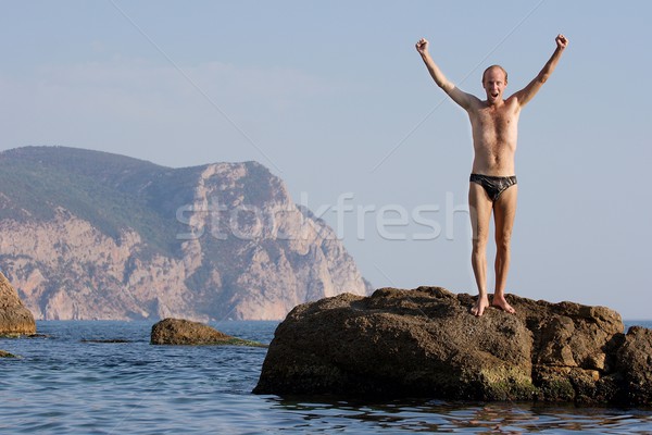 Strand man permanente klif zee gelukkig Stockfoto © Gudella