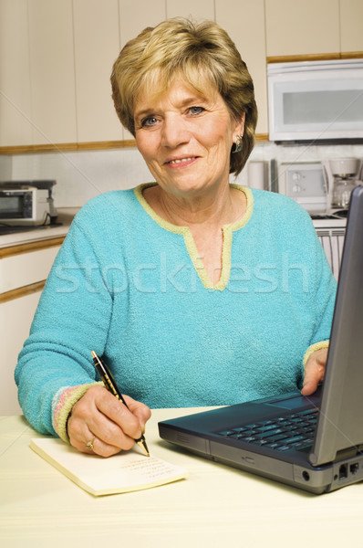 Femme note utilisant un ordinateur portable supérieurs cuisine portable [[stock_photo]] © Habman_18