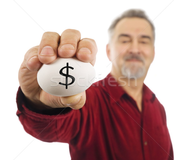 Mature man holds an egg with a dollar sign ($) written on it. Stock photo © Habman_18