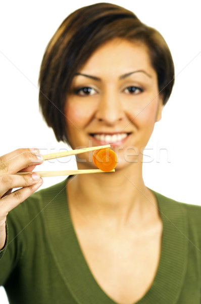 Young woman holds a carrot slice with chopsticks in front of her Stock photo © Habman_18