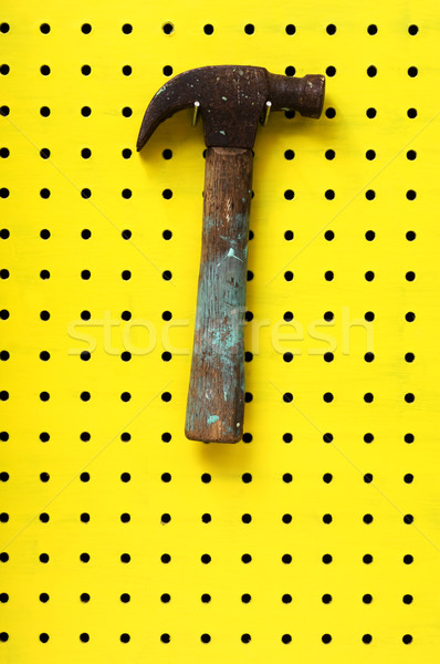 Hammer hangs on two hooks from yellow peg board Stock photo © Habman_18