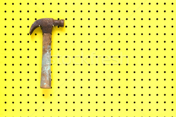Old claw hammer hangs on two hooks from yellow peg board Stock photo © Habman_18