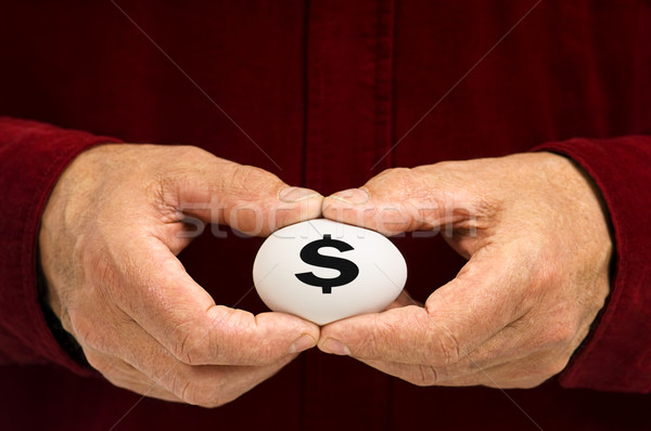 Man holds white egg with the dollar sign ($) written on it Stock photo © Habman_18