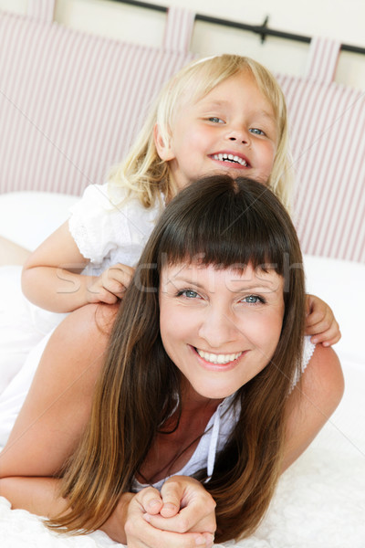 Mother and daughter posing happily in bed Stock photo © hannamonika