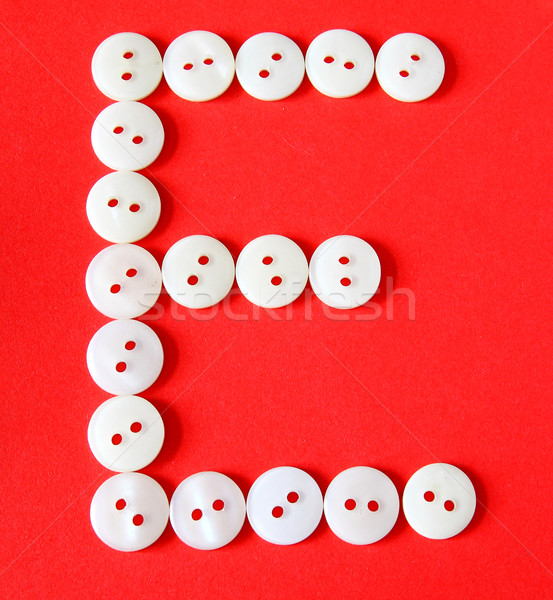 Letter 'E' from buttons on a red background  Stock photo © happydancing