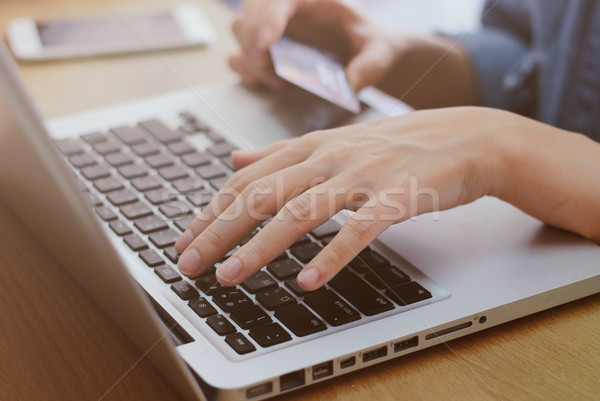 Woman’s hands holding credit card and using laptop, online sho Stock photo © happydancing