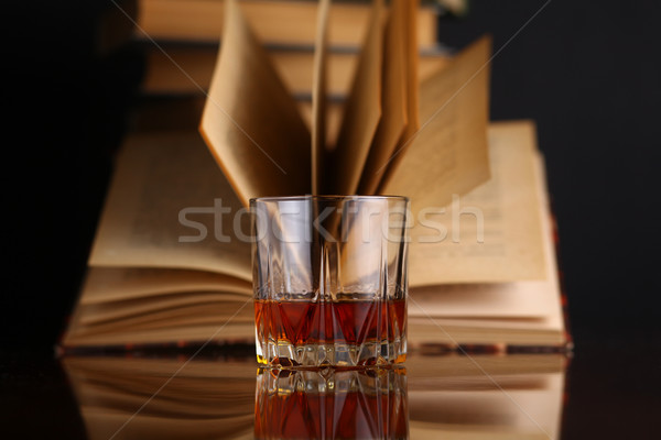 Stock photo: Glass of whiskey and books