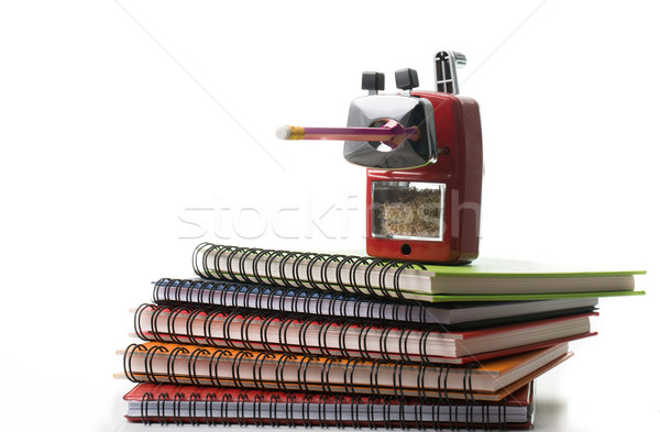 Red color metal pencil sharpener on top colorful books isolated  Stock photo © hin255