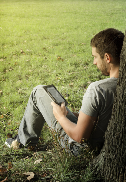 Stock photo: Young man reading e-book