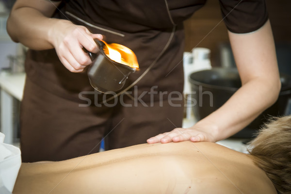 Massaging of young woman with paraffin wax Stock photo © Hochwander